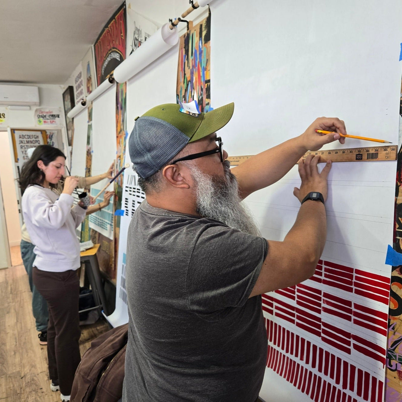 Two people working on art in a studio during a john king signpainting workshop