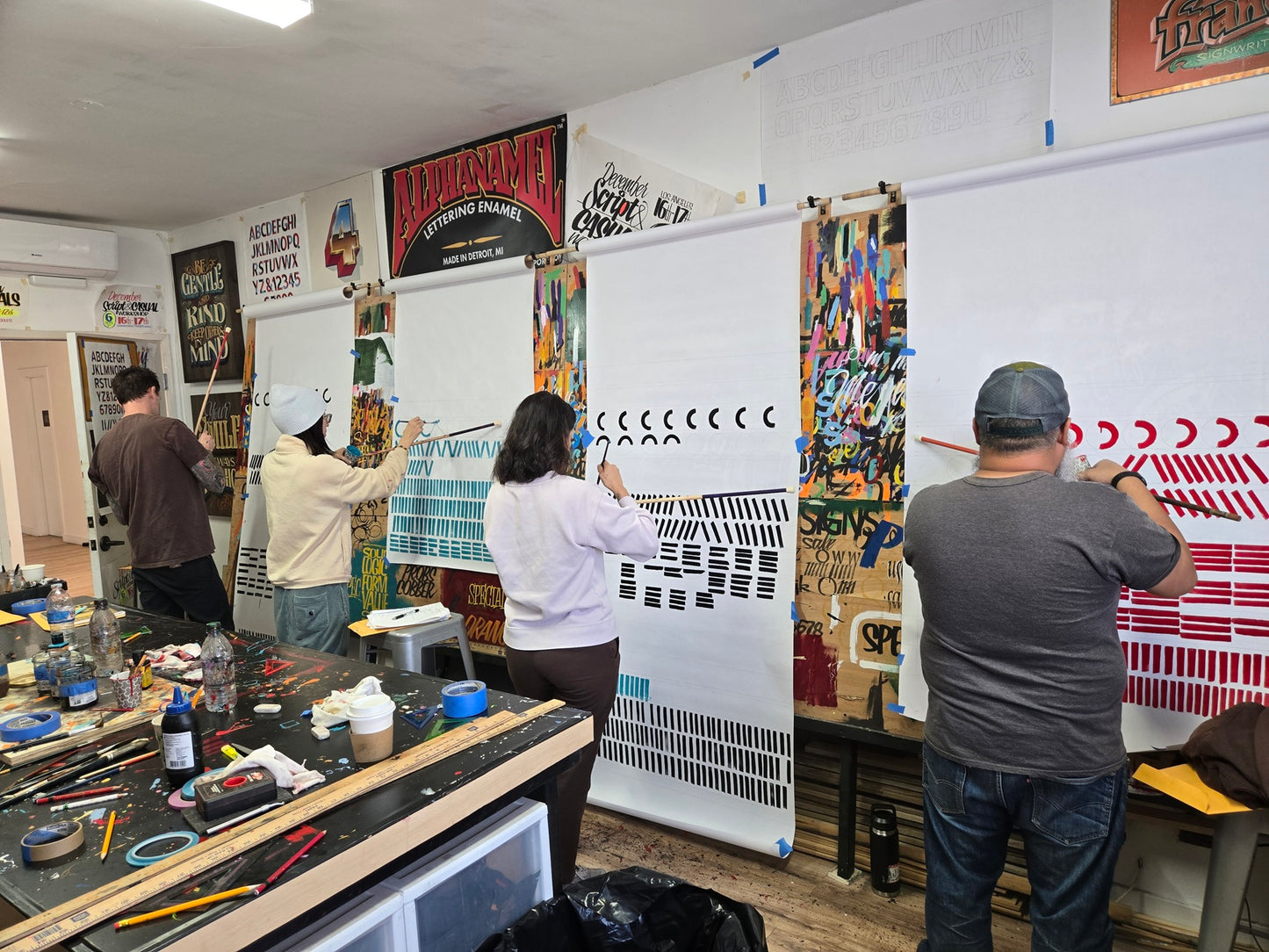 People working in a sign painting workshop with john King